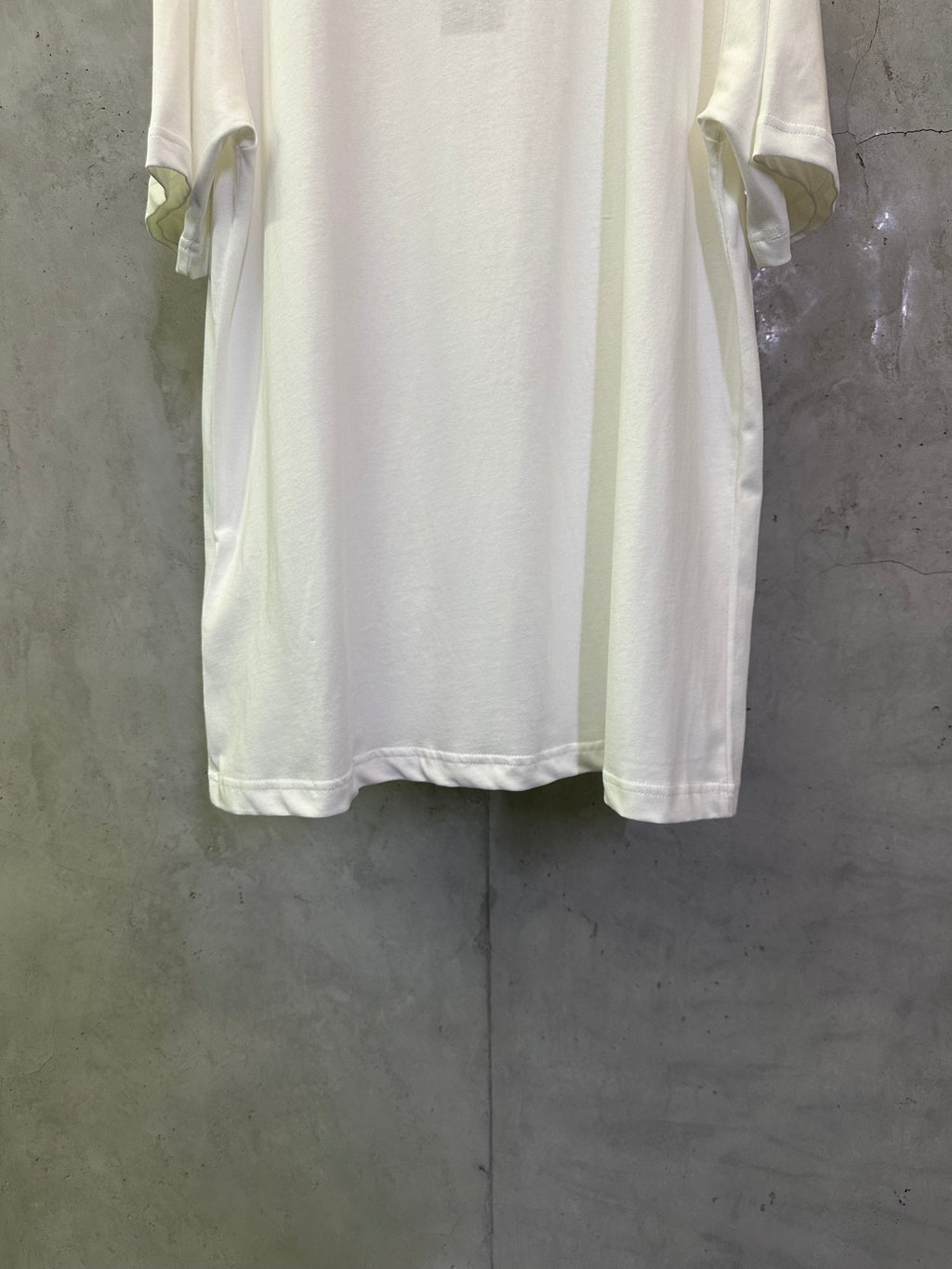 Dior white T-shirt back view with sleeve cuffs and curved hem