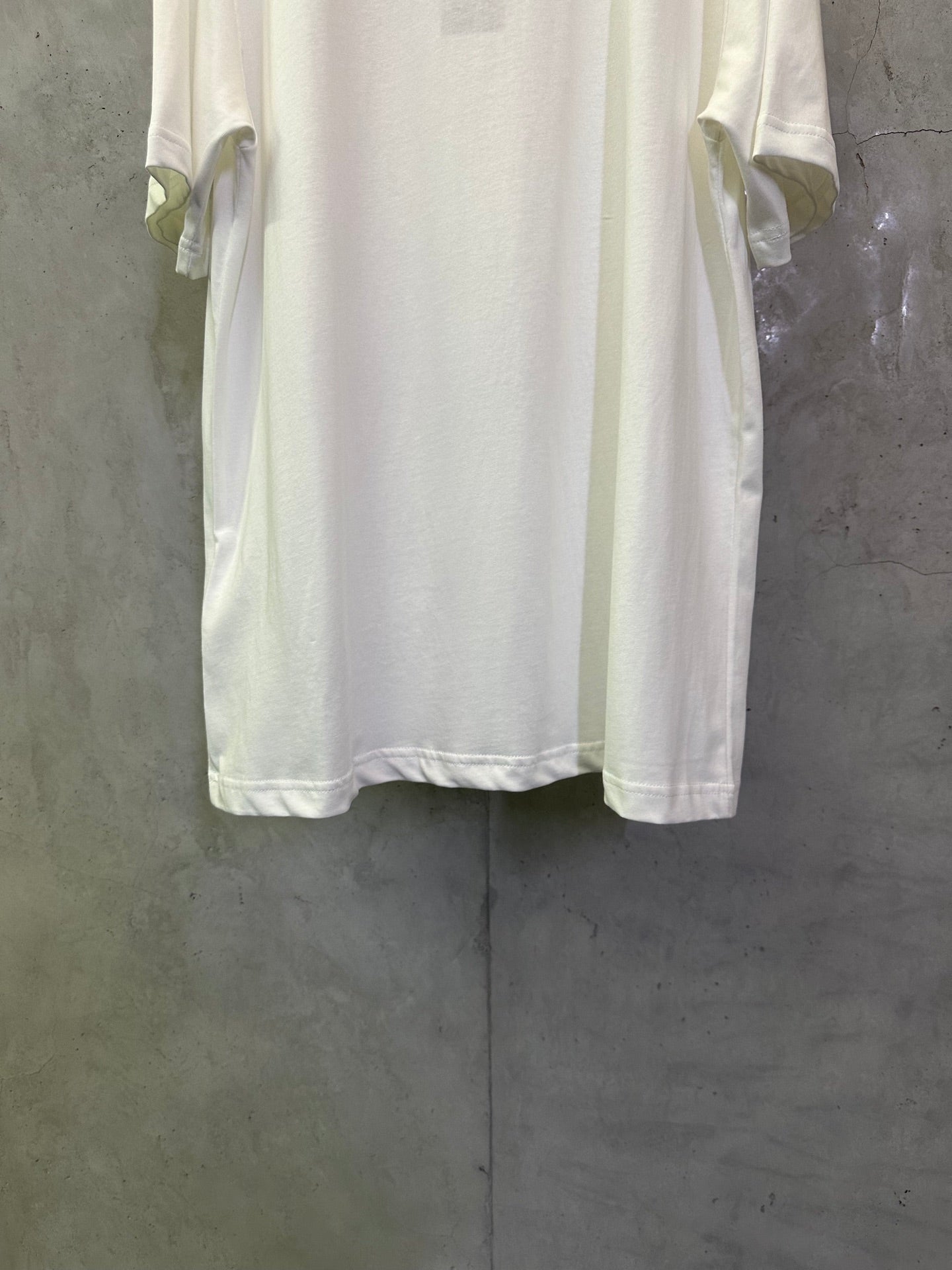 Dior white T-shirt back view with sleeve cuffs and curved hem