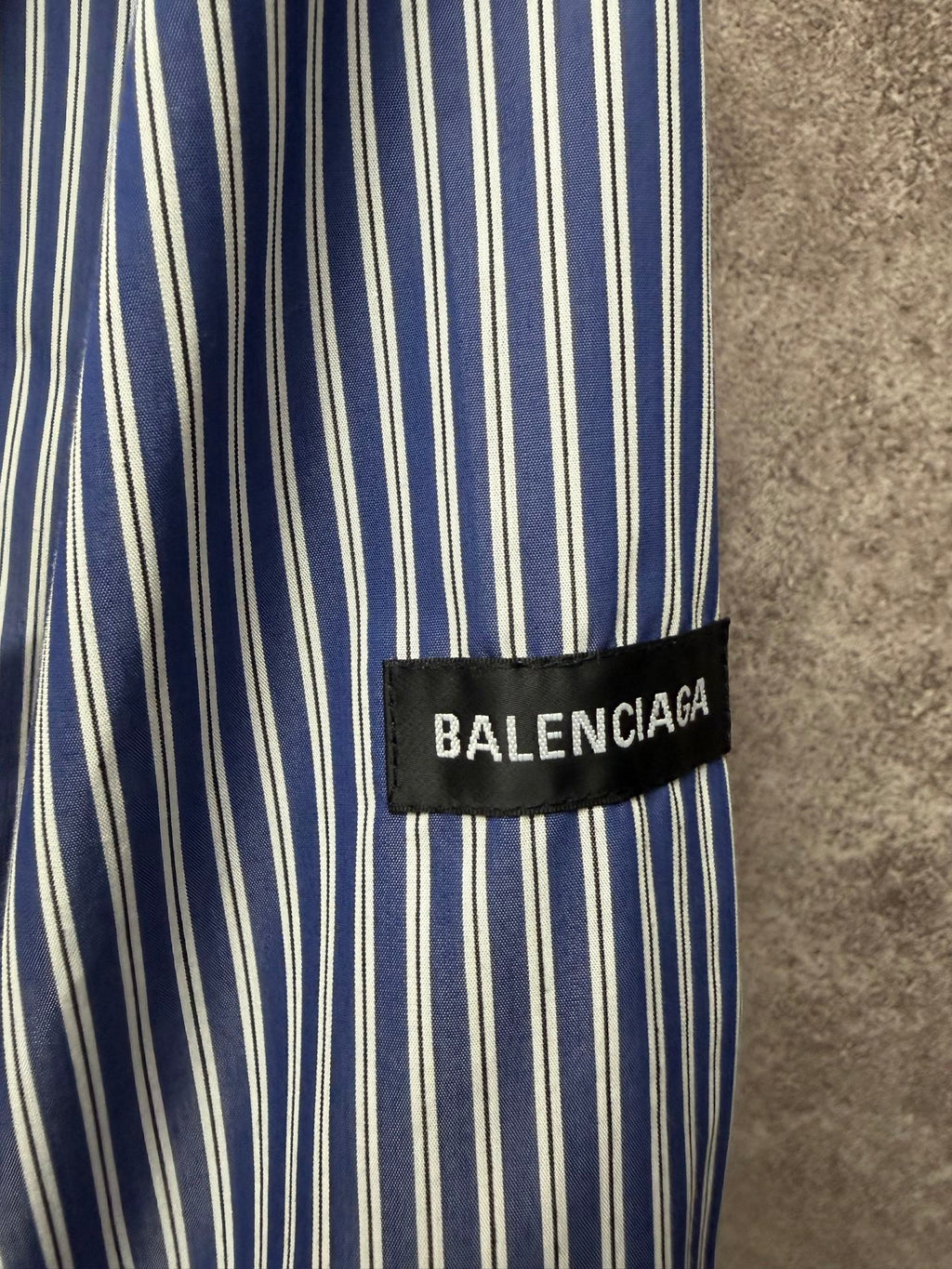 Striped shirt fabric with vertical blue-and-white lines, BALENCIAGA logo cuff label.