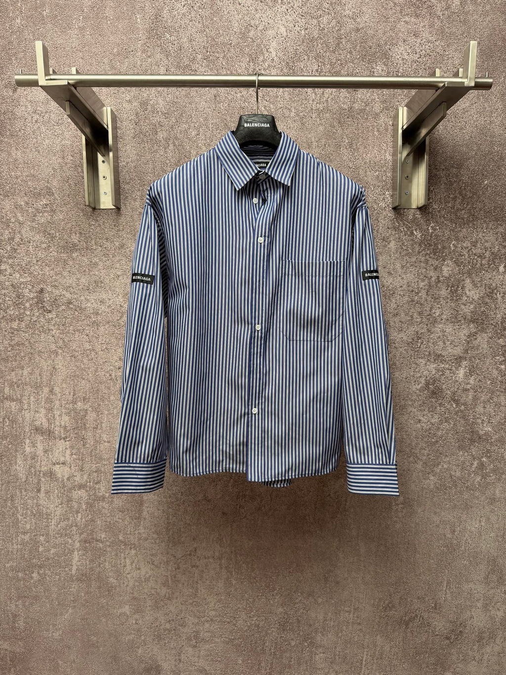 Long-sleeve button-up shirt with vertical blue-and-white stripes, button front, chest pocket.