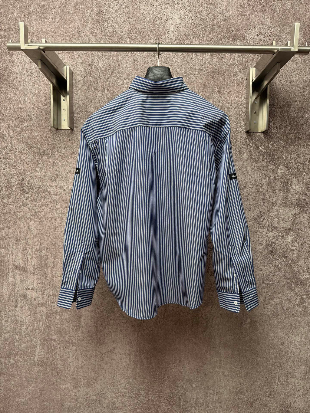 Long-sleeve button-up shirt with vertical blue-and-white stripes, standing collar, back view.