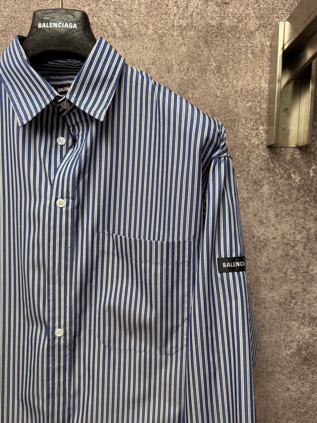 Long-sleeve striped button-up shirt with spread collar, chest pocket, logo sleeve patches.