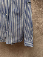 Striped button-up shirt hem and cuff, vertical blue-and-white stripes with banded cuff.