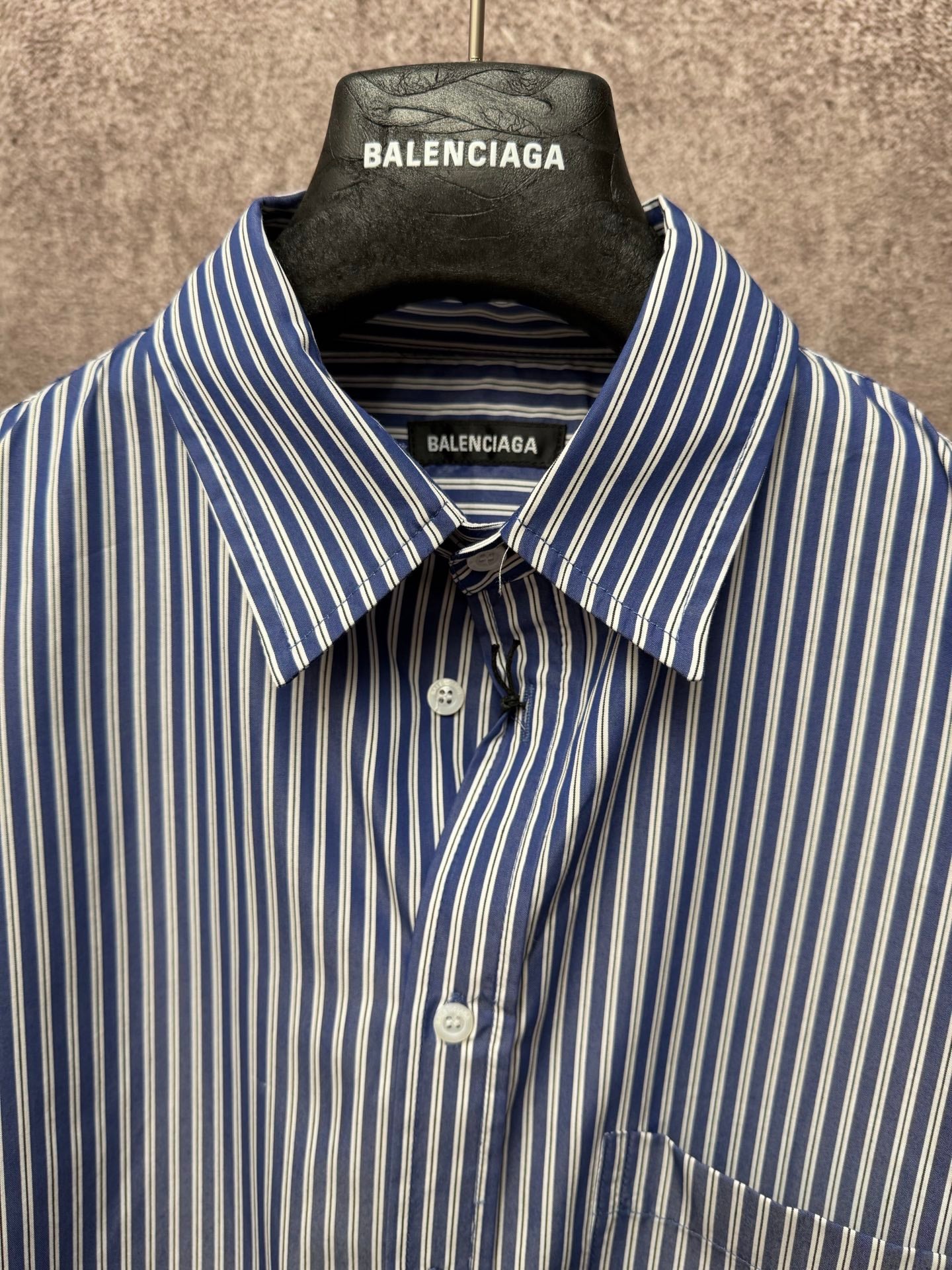 Striped button-up shirt with spread collar, front buttons, chest pocket, and logo labels.