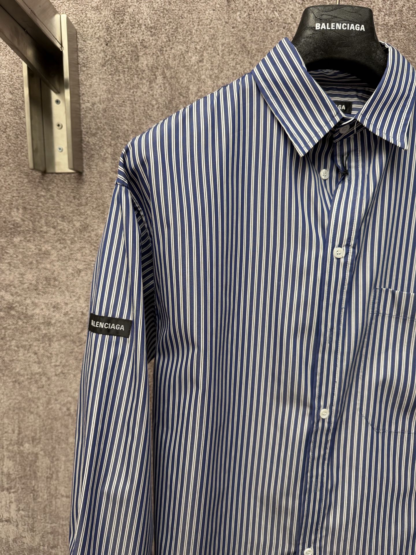 Long-sleeve striped button-up shirt with spread collar and button front, sleeve logo tab.