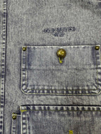Denim jacket chest pocket close-up with LOUIS VUITTON PARIS logo and gold stud