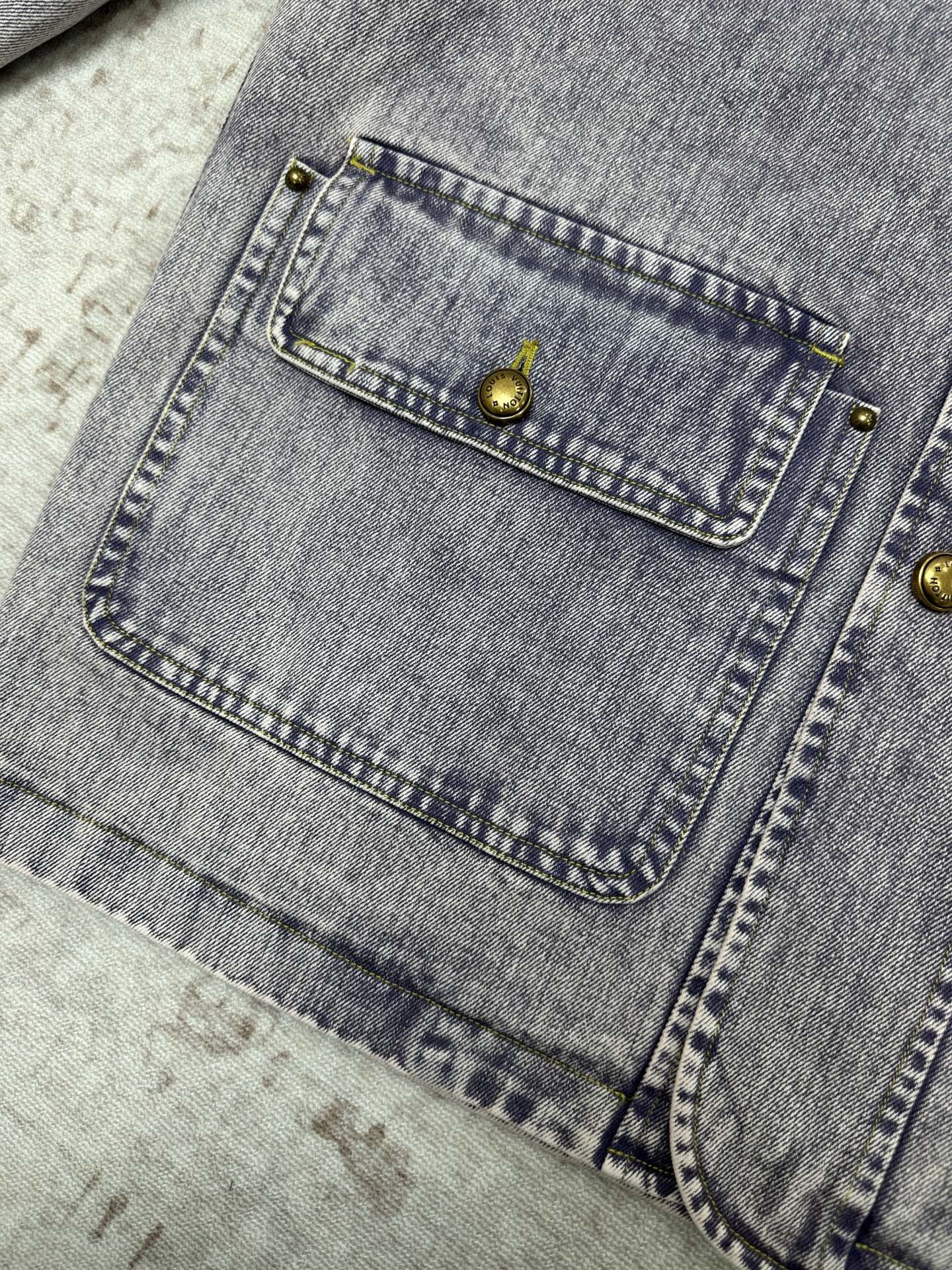 Light blue denim jacket interior pocket with gold-tone button