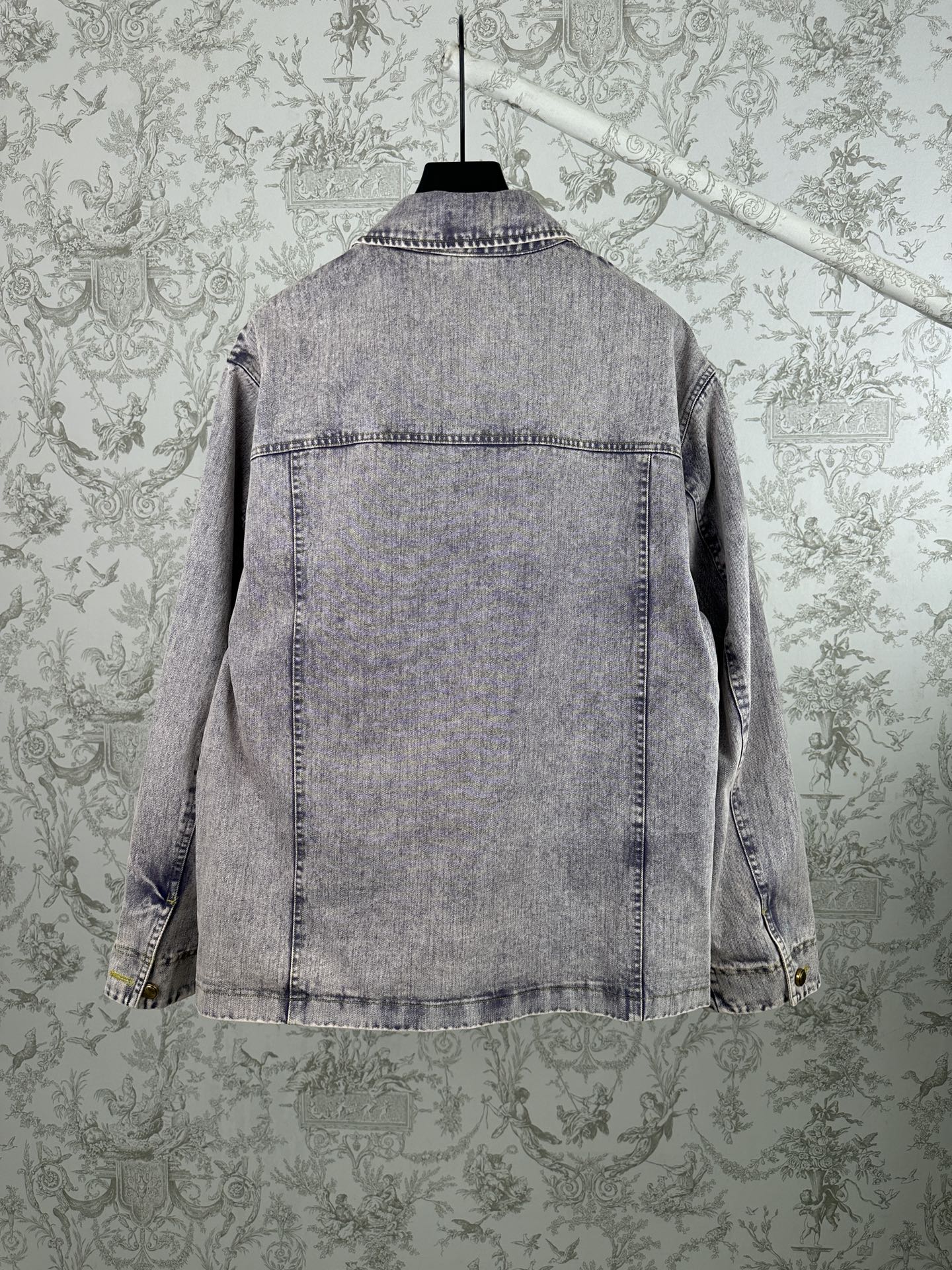 Light blue denim jacket, back view, buttoned yoke and hem stitching