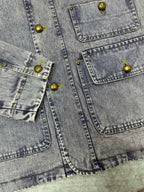 Light blue denim jacket front panels with gold-tone buttons and flap pockets
