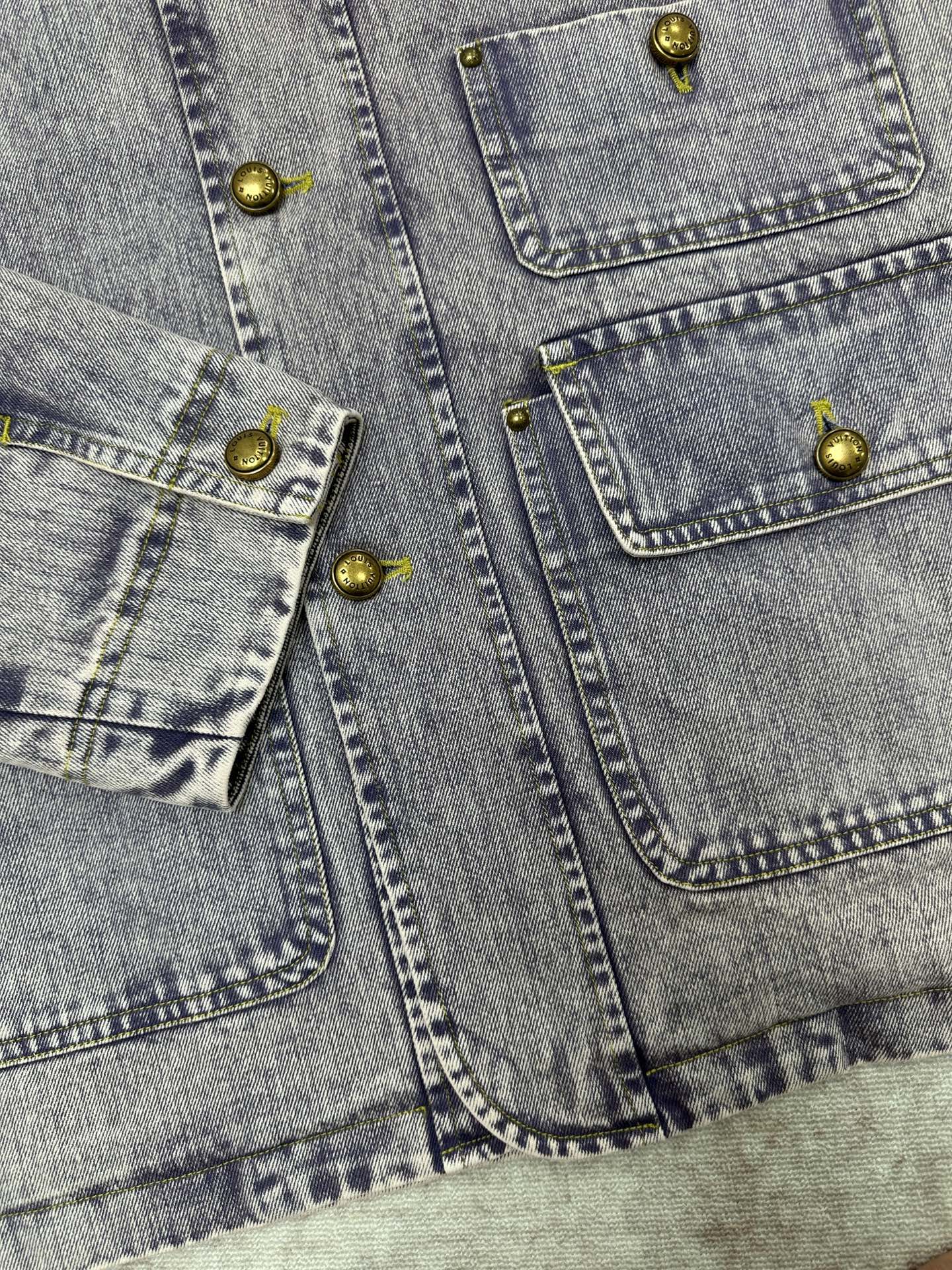 Light blue denim jacket front panels with gold-tone buttons and flap pockets