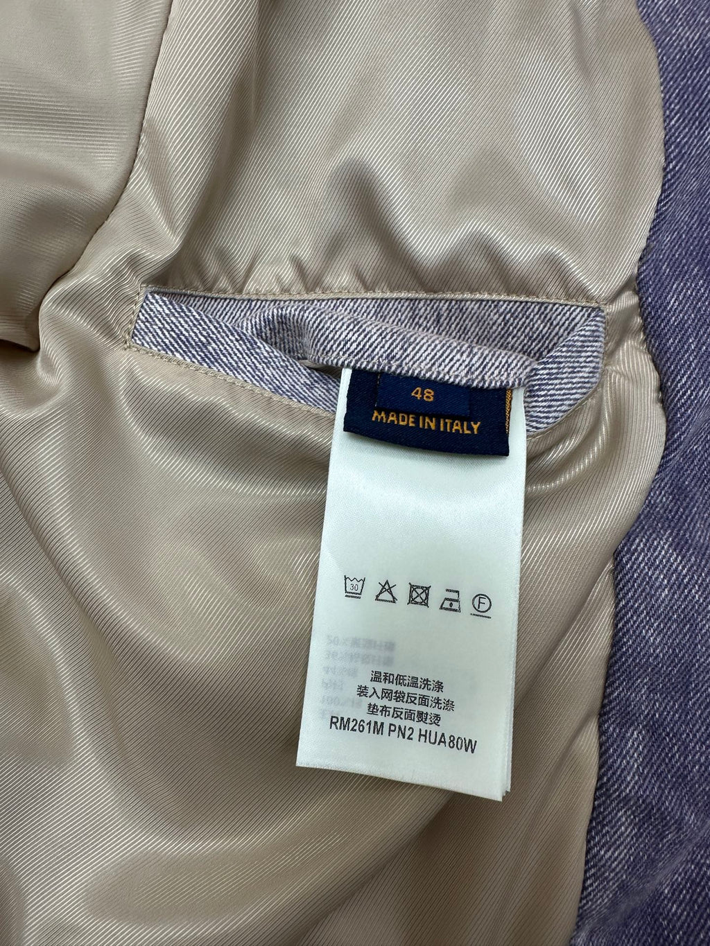 Denim jacket size and care tag: Made in Italy, size 48, care symbols