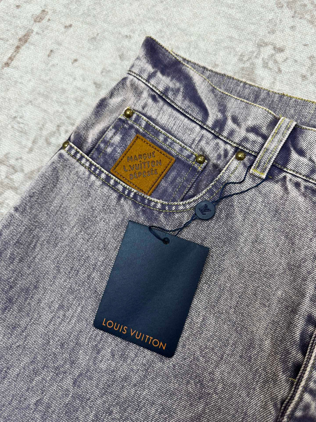 Denim jeans waistband with Louis Vuitton logo patch and belt loop hardware