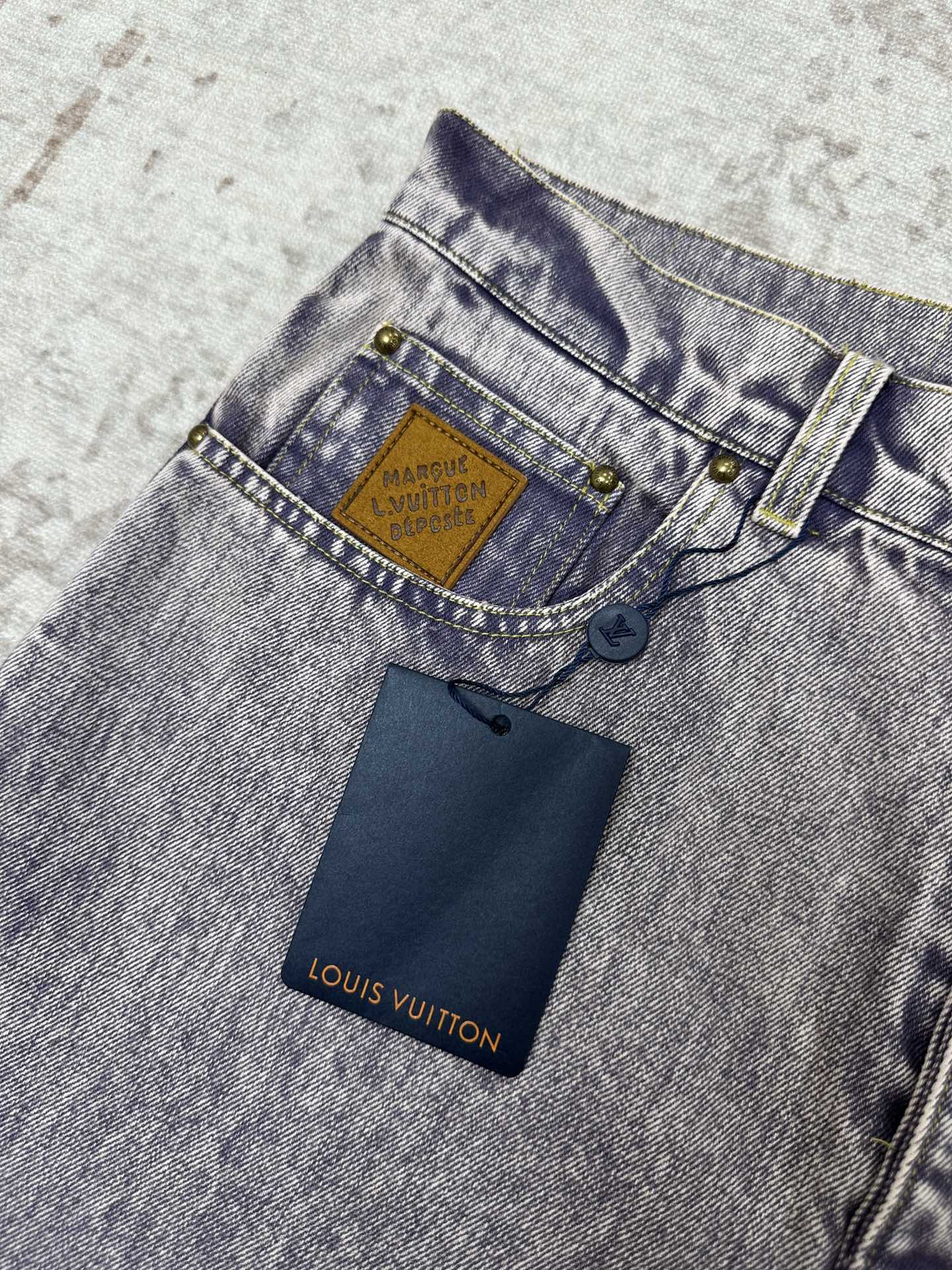Denim jeans waistband with Louis Vuitton logo patch and belt loop hardware