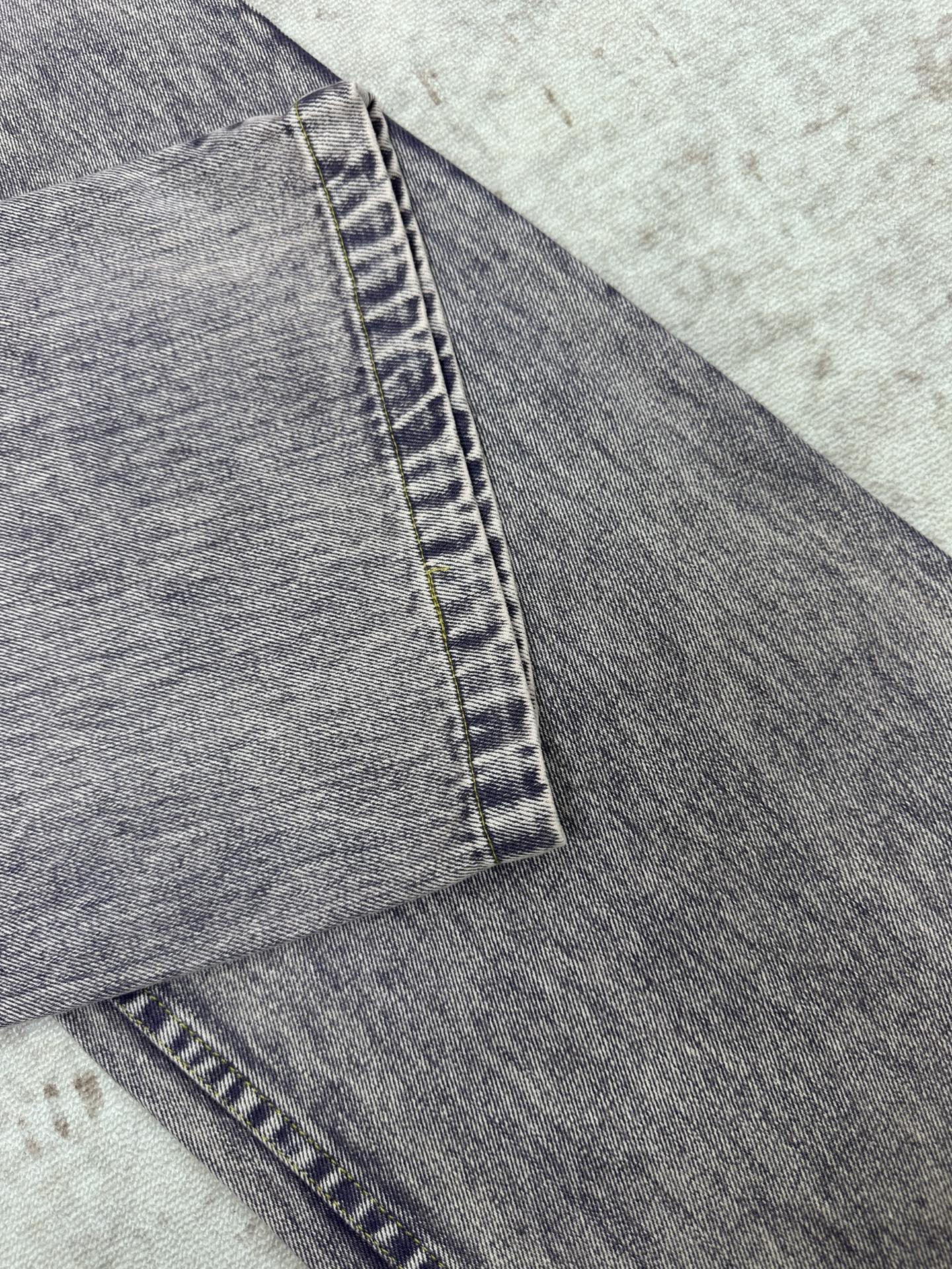 Light wash denim jeans hem with side seam and cuffed fold
