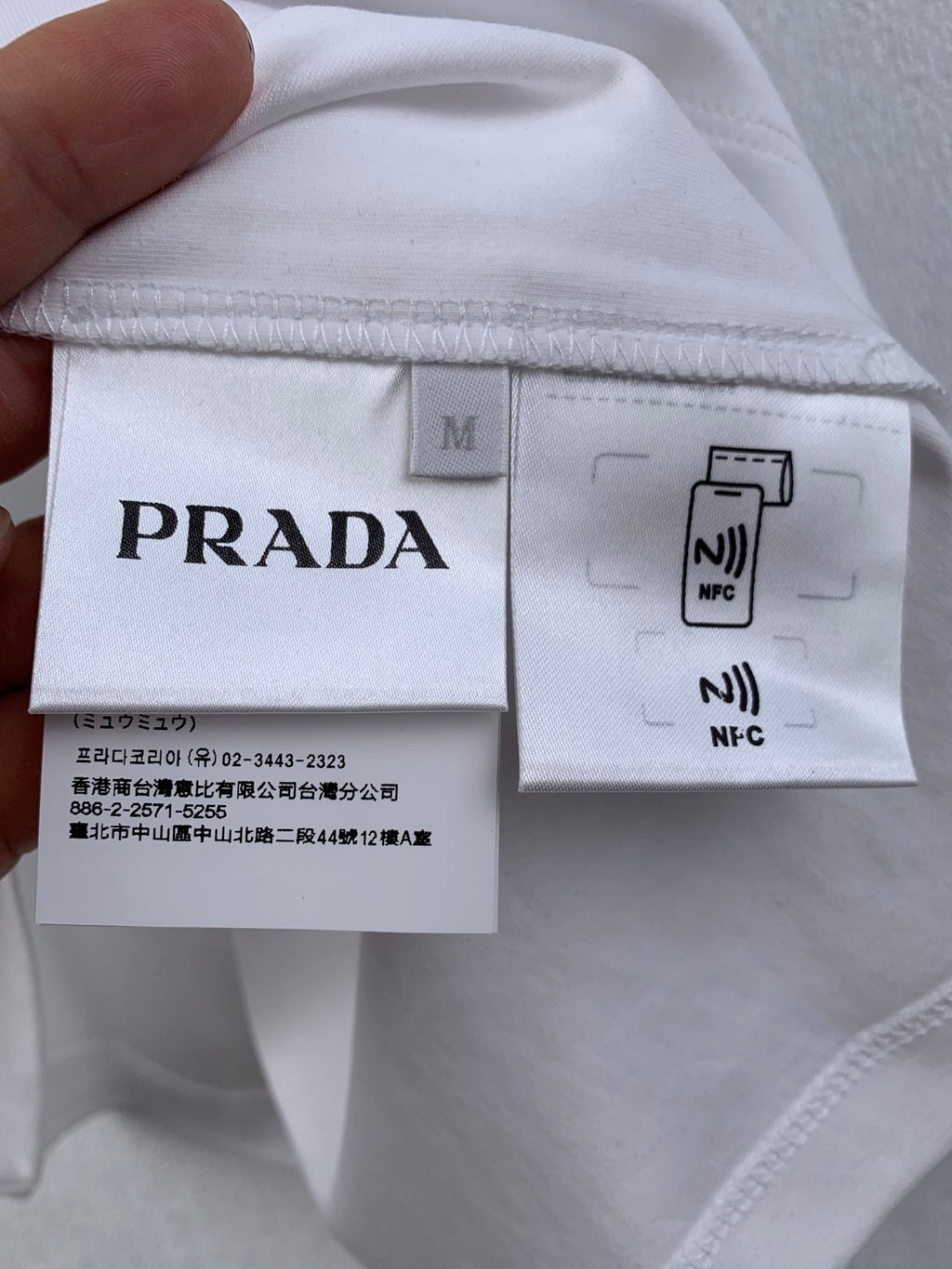 White T-shirt inside tag with Prada size M and NFC label