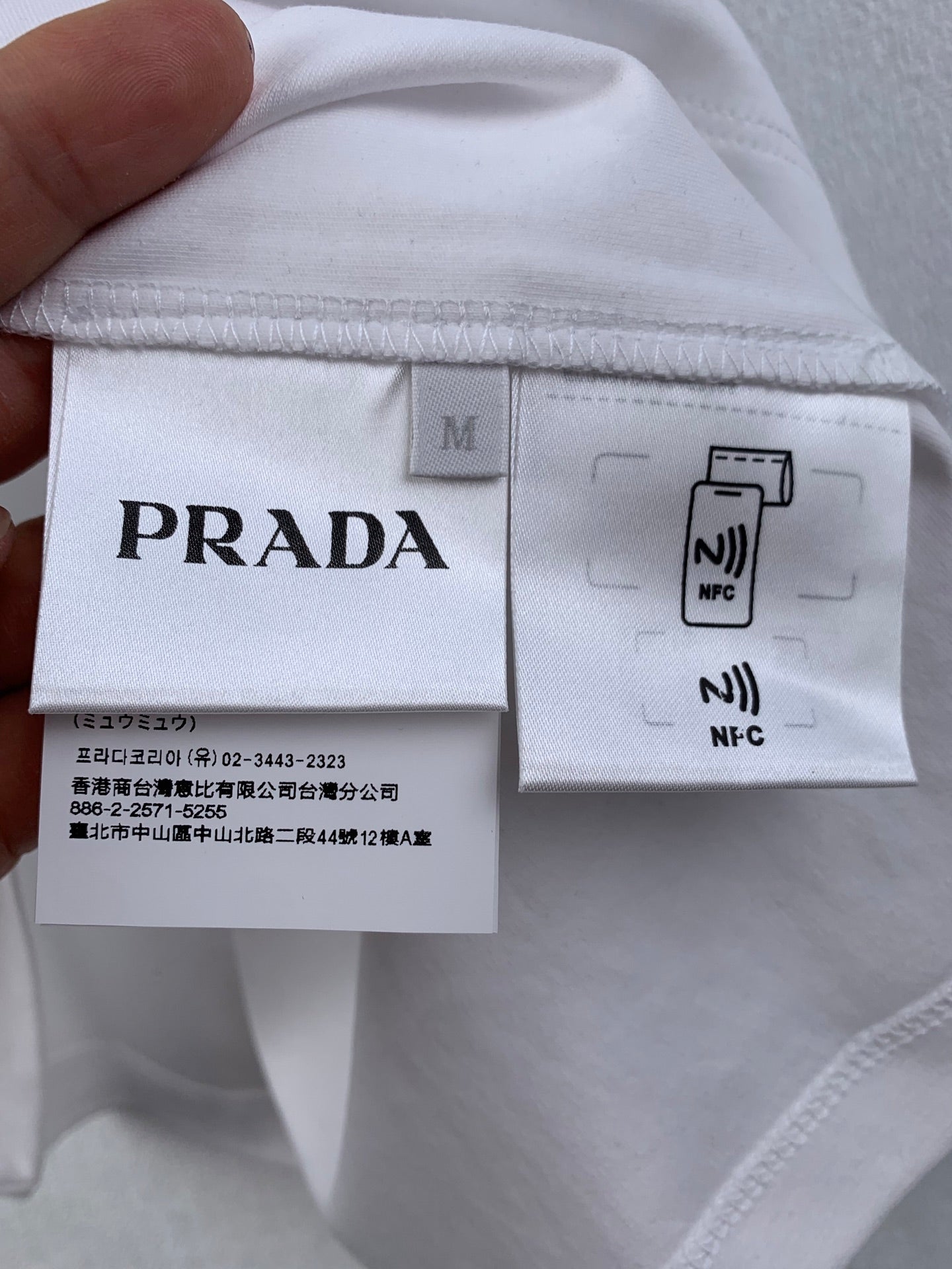 White T-shirt inside tag with Prada size M and NFC label