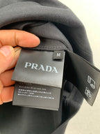 PRADA neck label and size M tag on dark T-shirt collar.