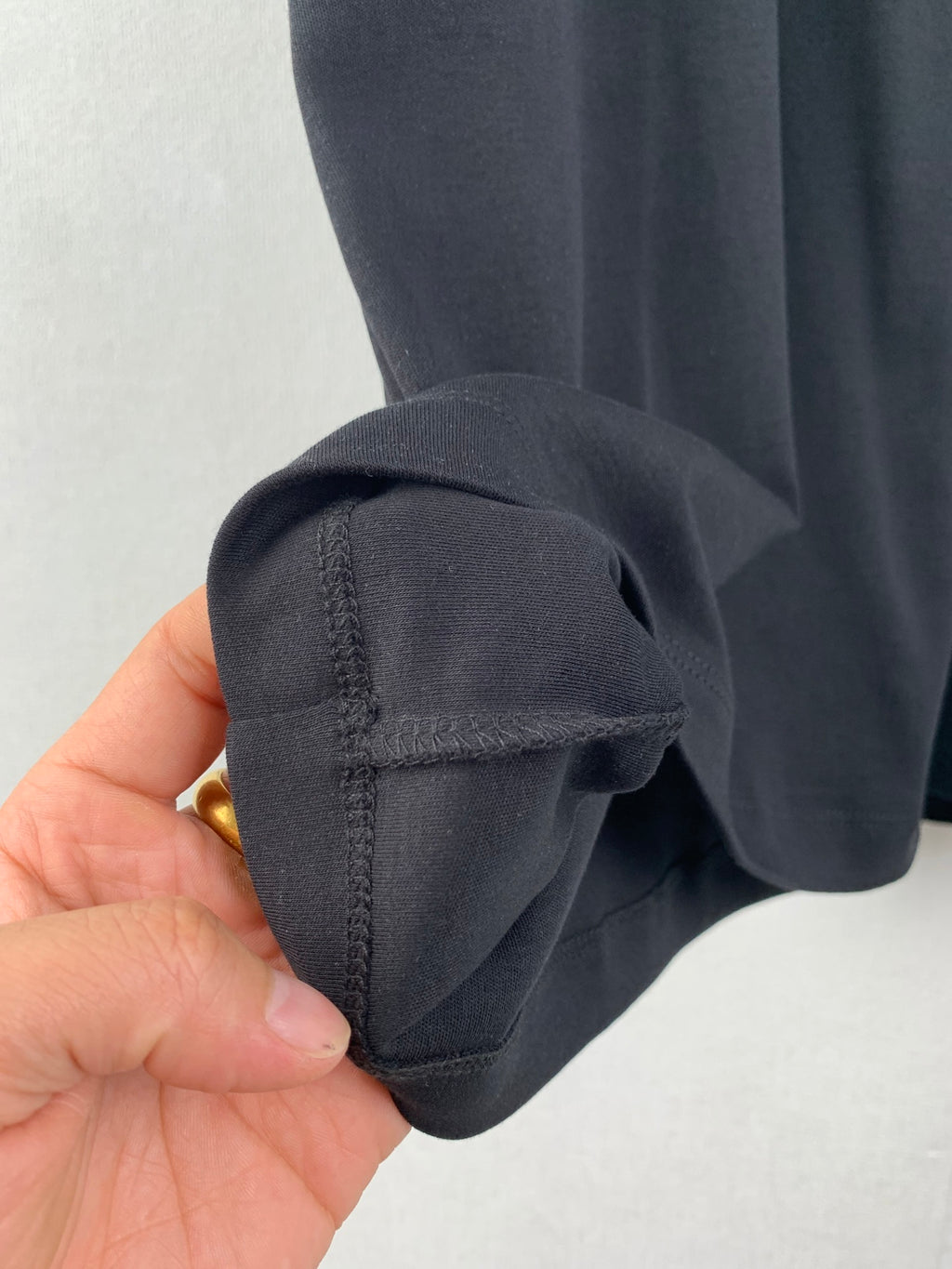 Close-up of dark short-sleeve cuff and seam detail.