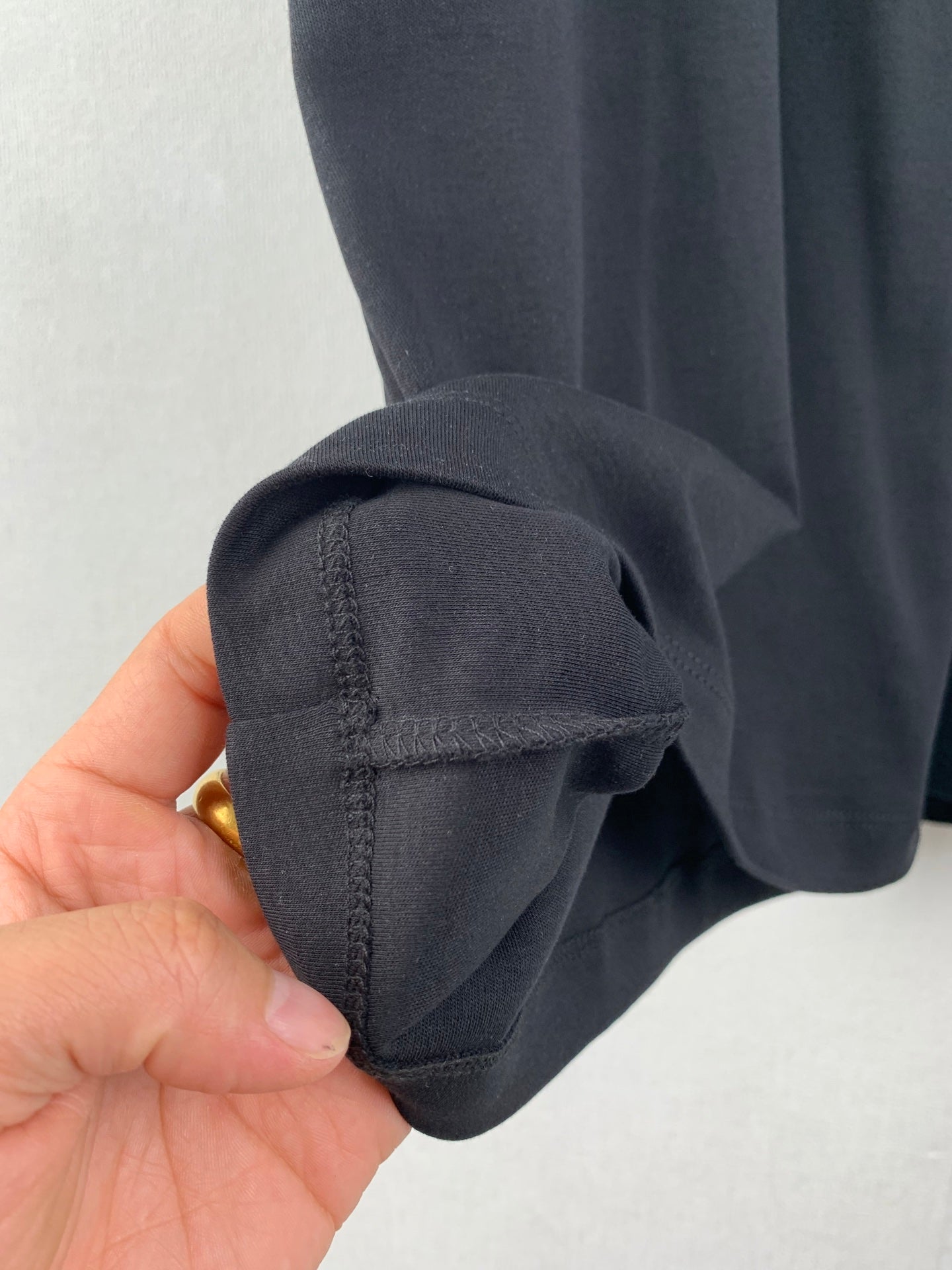 Close-up of dark short-sleeve cuff and seam detail.