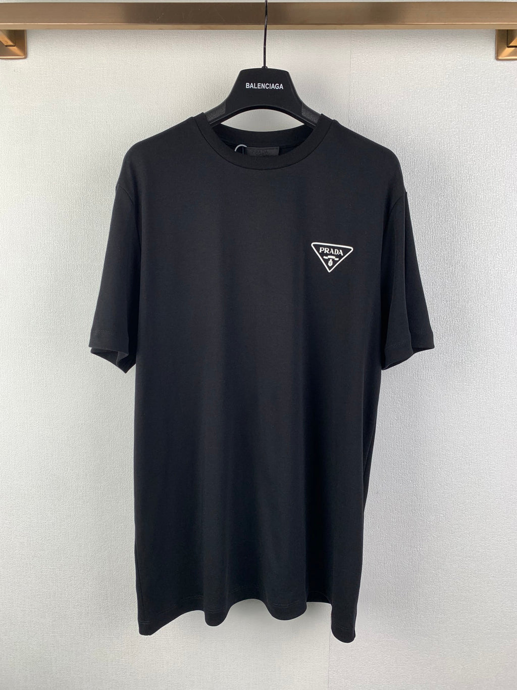 Black short-sleeve T-shirt with PRADA triangular chest logo, crew neck.
