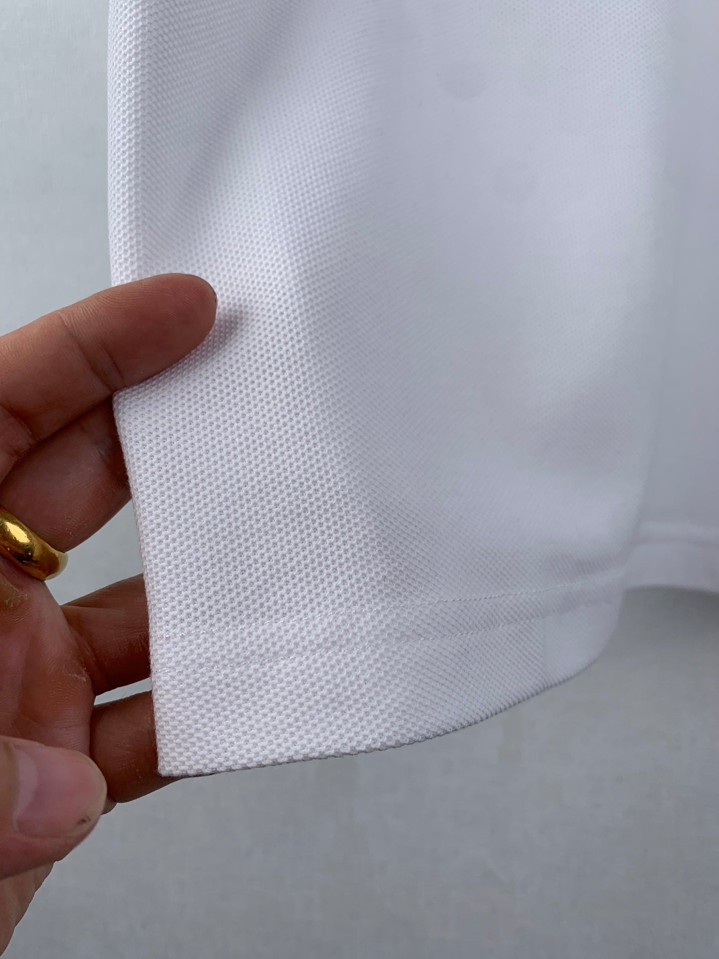 White polo hem fabric close-up with drape detail