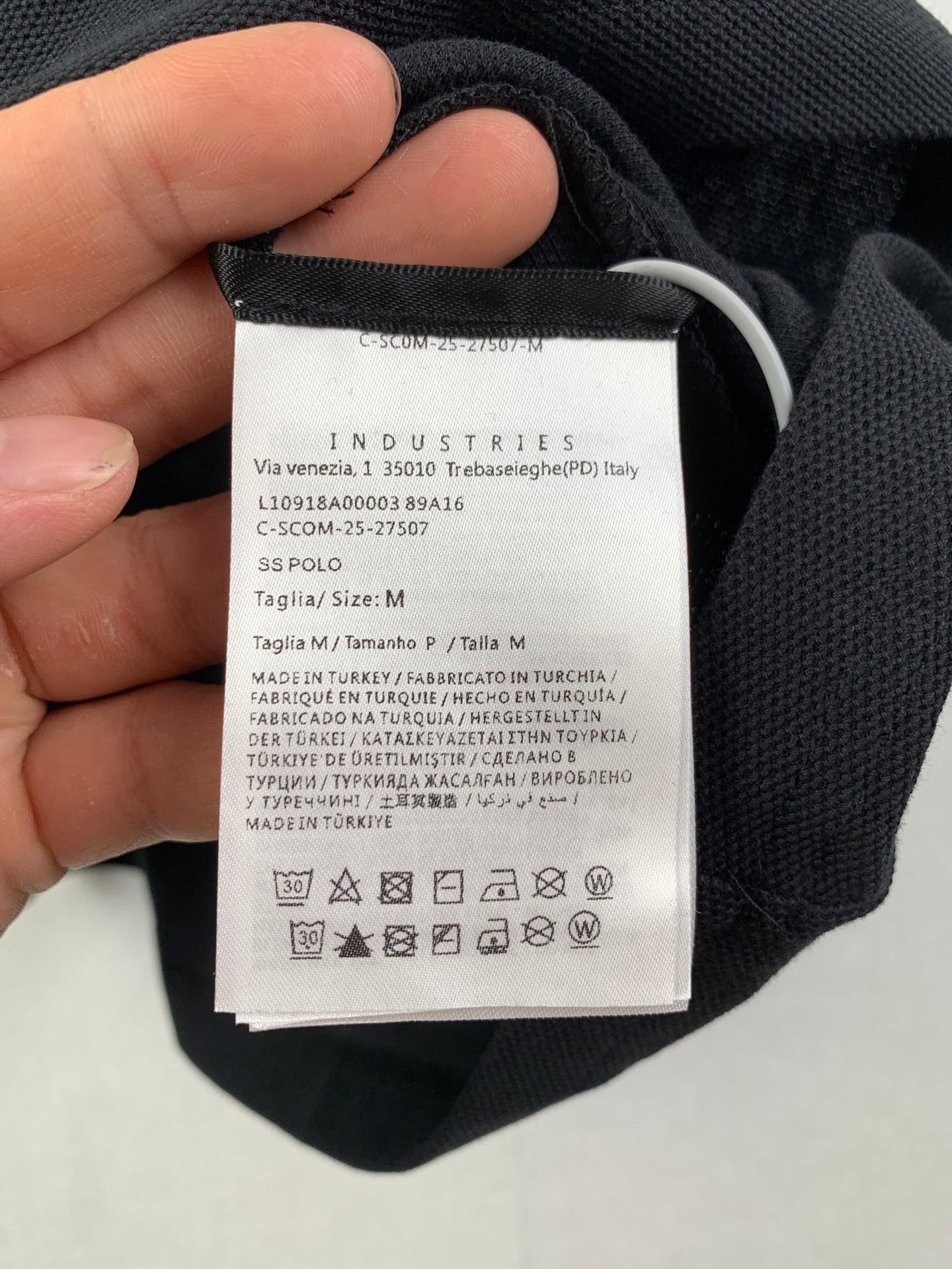 Inside label with size and care symbols on dark polo fabric