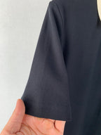 Moncler polo shirt sleeve close-up showing dark textured knit