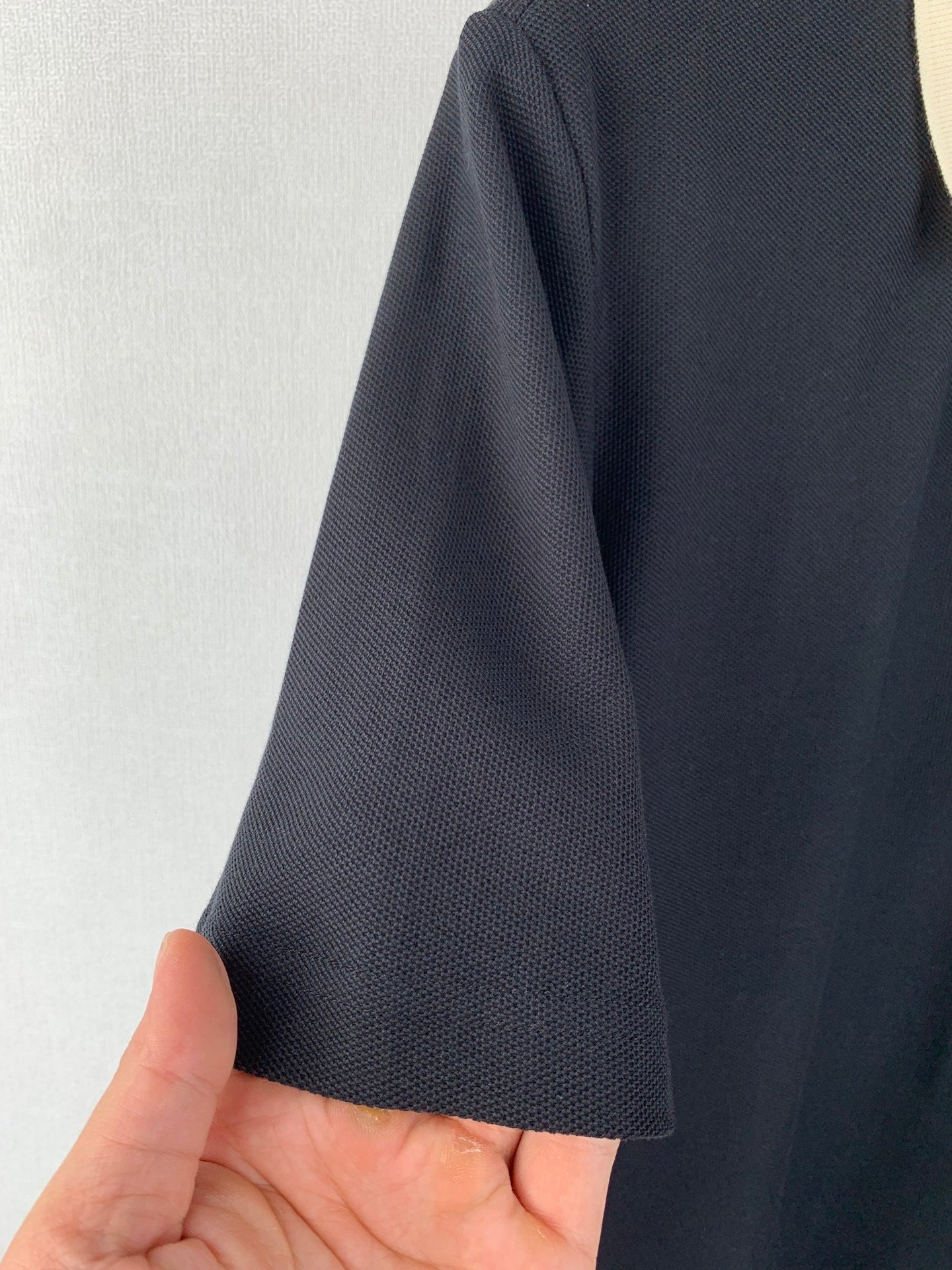 Moncler polo shirt sleeve close-up showing dark textured knit