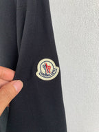 Moncler polo shirt sleeve patch logo on dark fabric