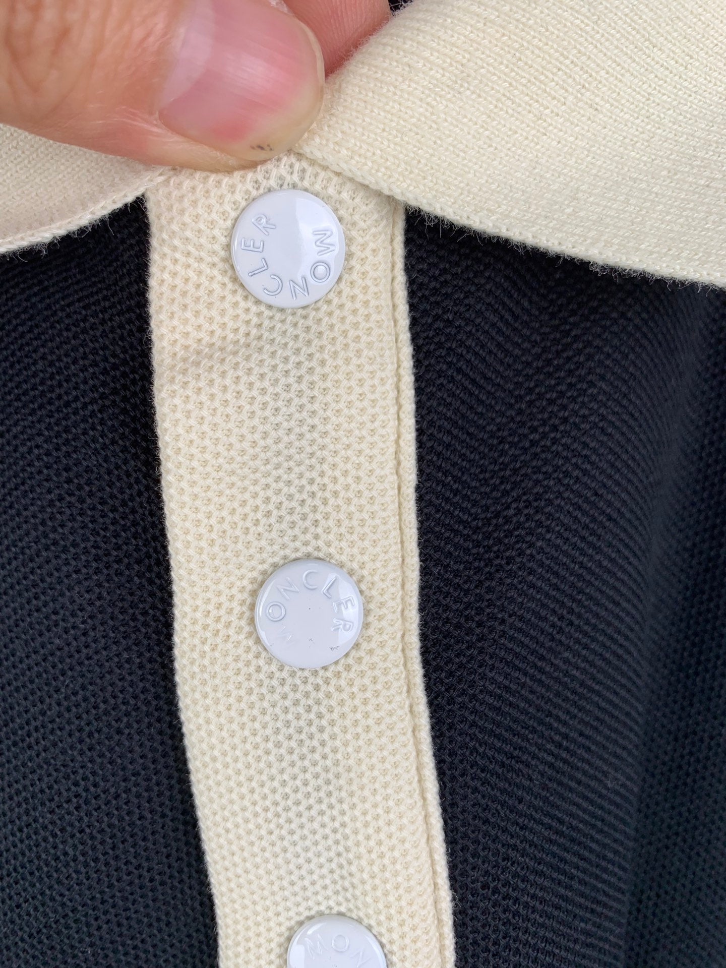 Moncler polo shirt placket detail with cream buttons and fabric texture