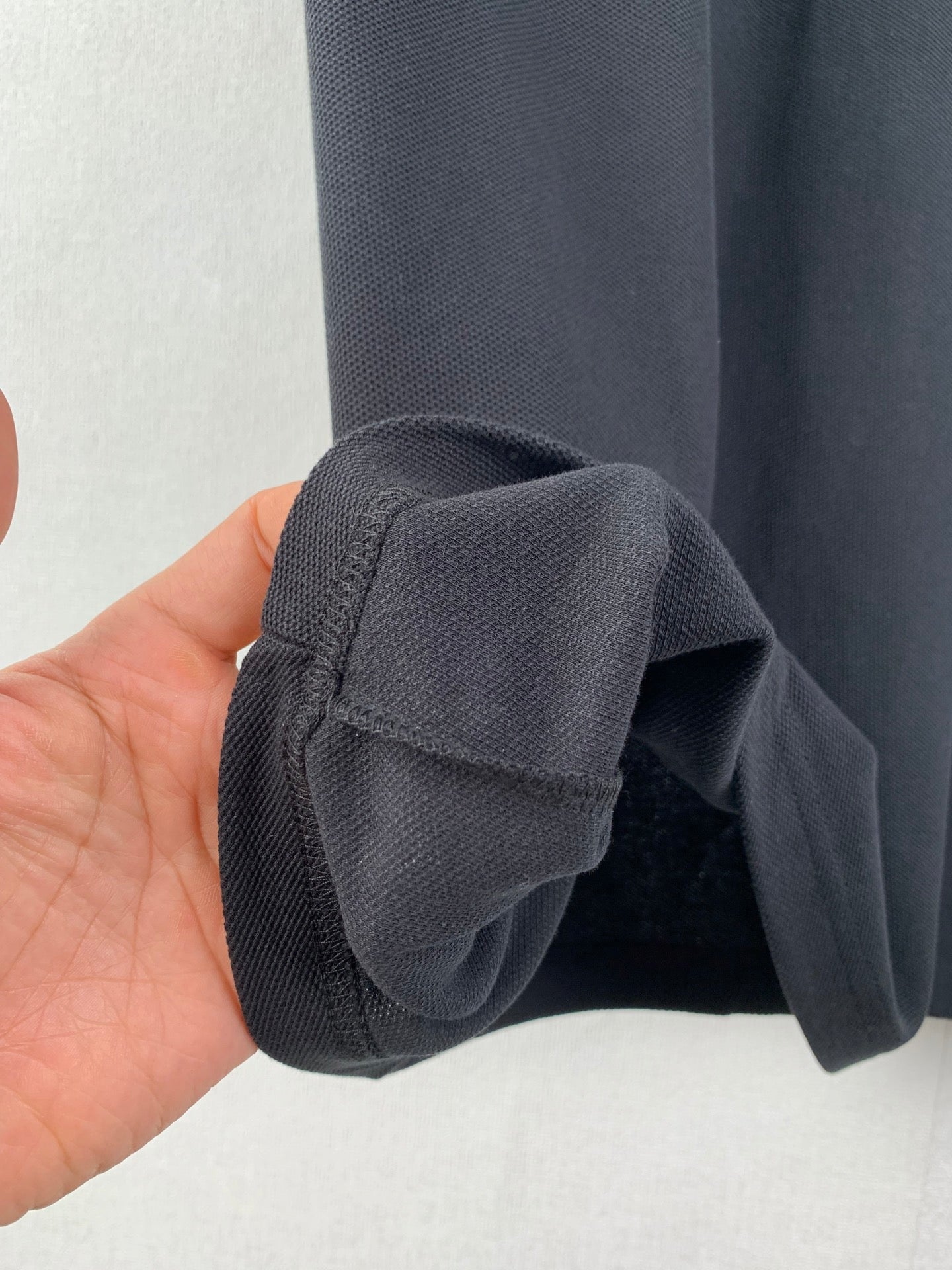 Dark fabric short sleeve cuff detail with stitched hem and folded edge