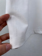 White T-shirt fabric seam detail near side hem, close-up