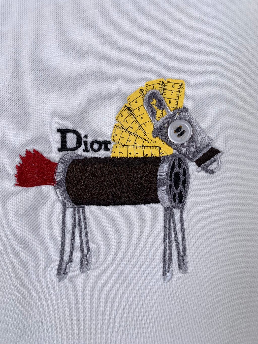 Embroidered Dior animal graphic with yellow ruler details on white fabric