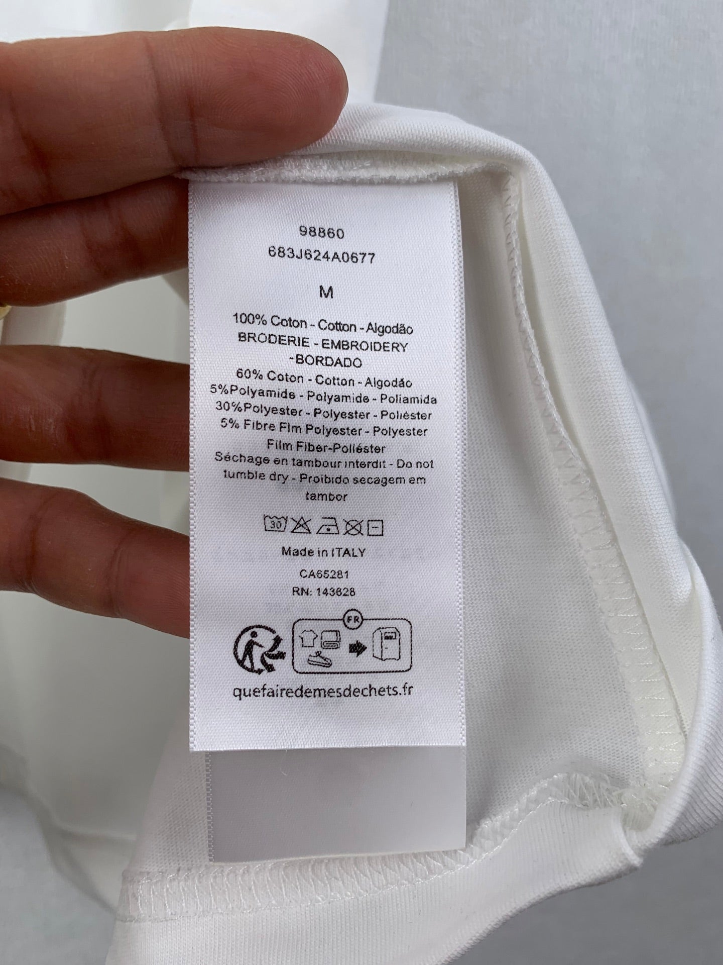 White T-shirt care label inside with size and material details