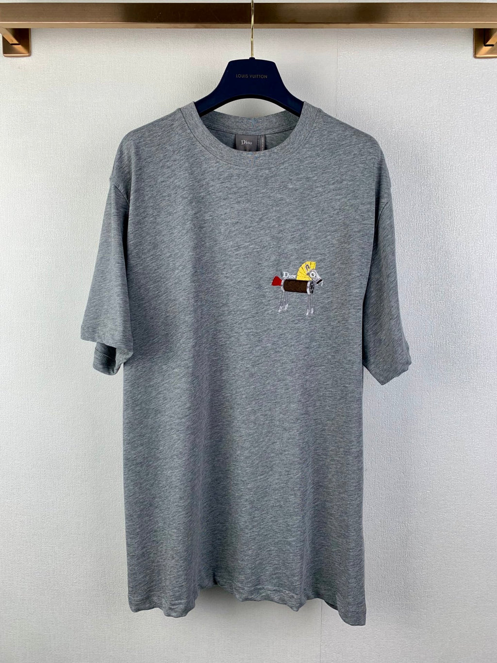 Gray short-sleeve T-shirt with small illustrated chest graphic, crew neck.