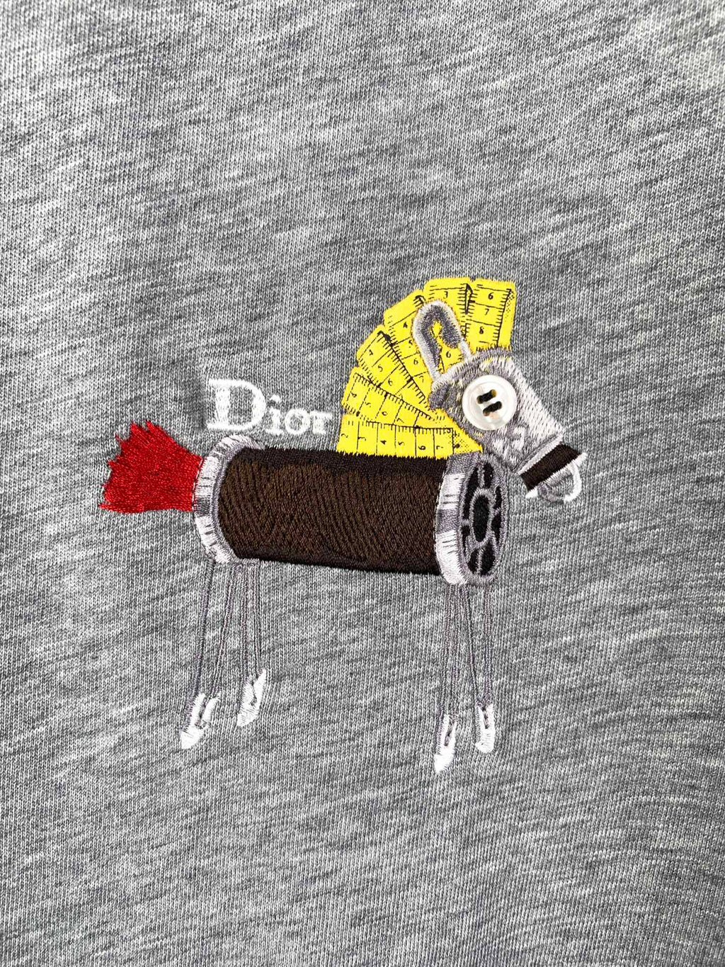 Close-up of gray T-shirt with colorful cartoon graphic applique on chest.