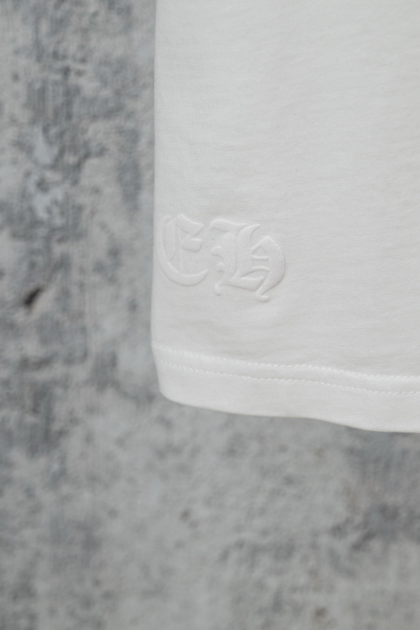 White T-shirt hem with subtle embossed logo