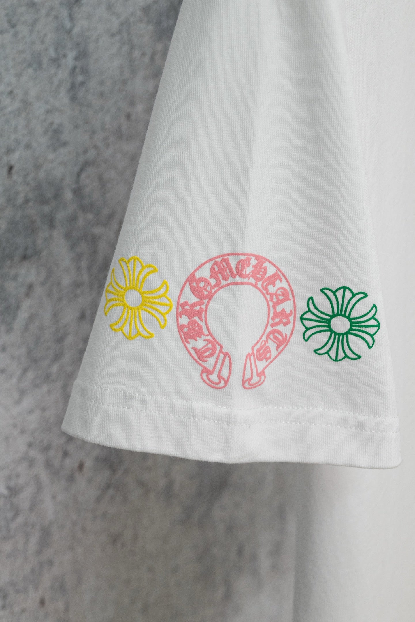 Chrome short T-shirt hem, white with small multicolor flower icons along the bottom edge