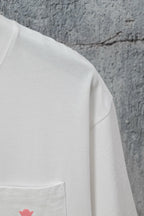 White short-sleeve T-shirt with side pocket seam and small pink logo mark