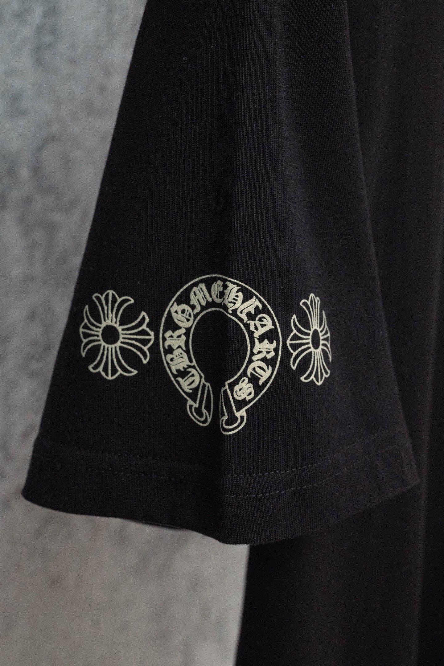 Black short-sleeve T-shirt close-up of side graphic near hem