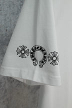 White T-shirt hem with small flower and horseshoe graphic print