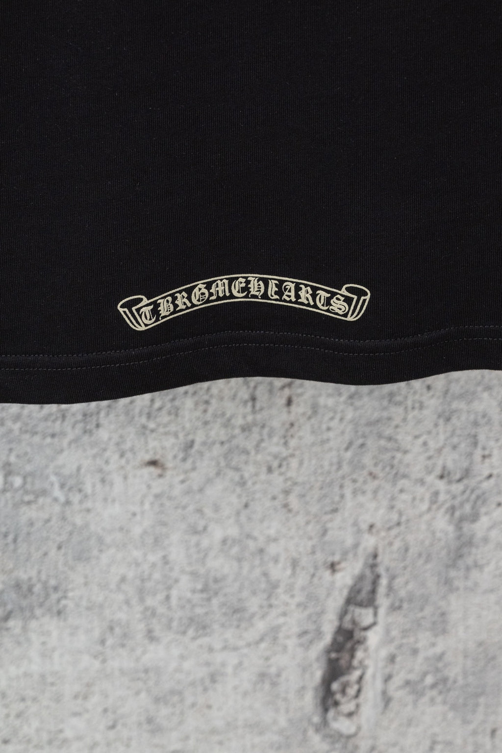 Black short-sleeve T-shirt hem with embroidered curved brand-style text