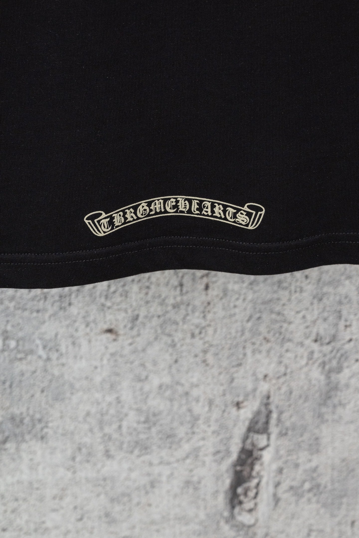 Black short-sleeve T-shirt hem with embroidered curved brand-style text