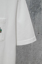 White short-sleeve T-shirt with side seam and hem, graphic pocket partially visible