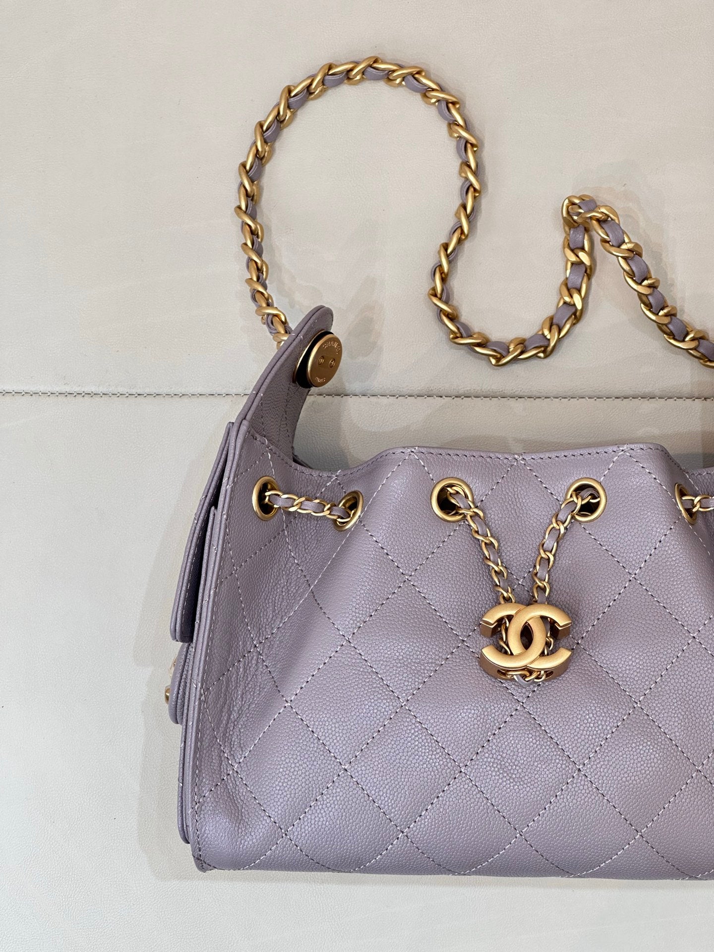 Lavender quilted handbag with gold chain handles and CC logo front hardware