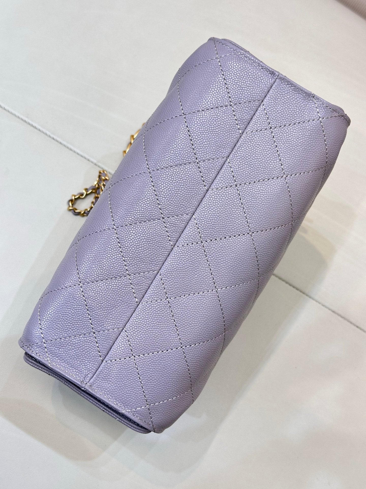 Lavender quilted phone case with gold chain strap and diagonal seam stitching