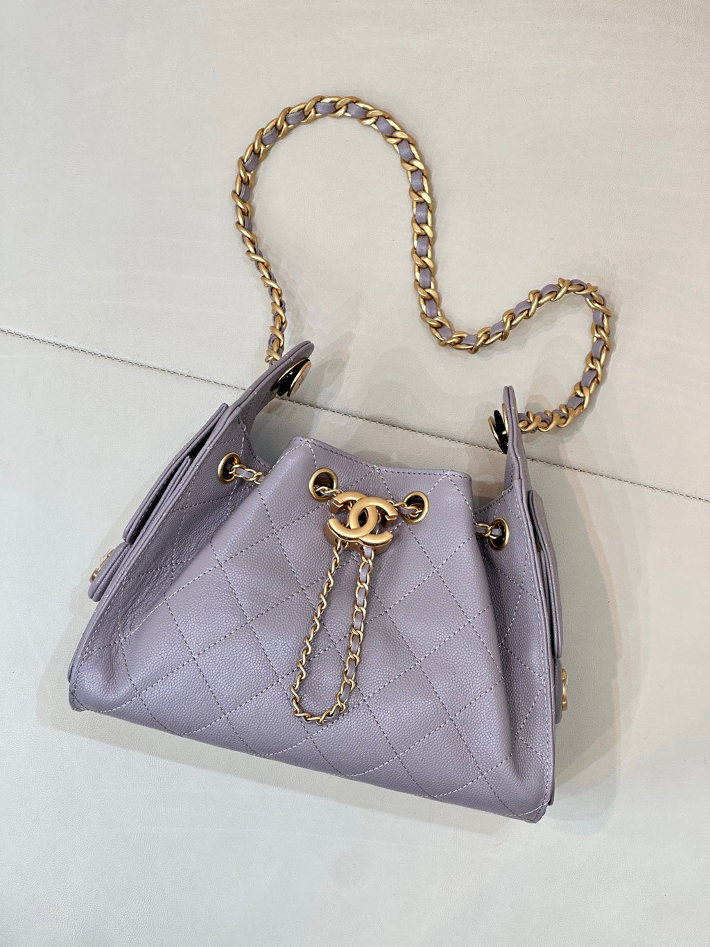 Lavender quilted handbag with gold chain shoulder strap and CC logo on front