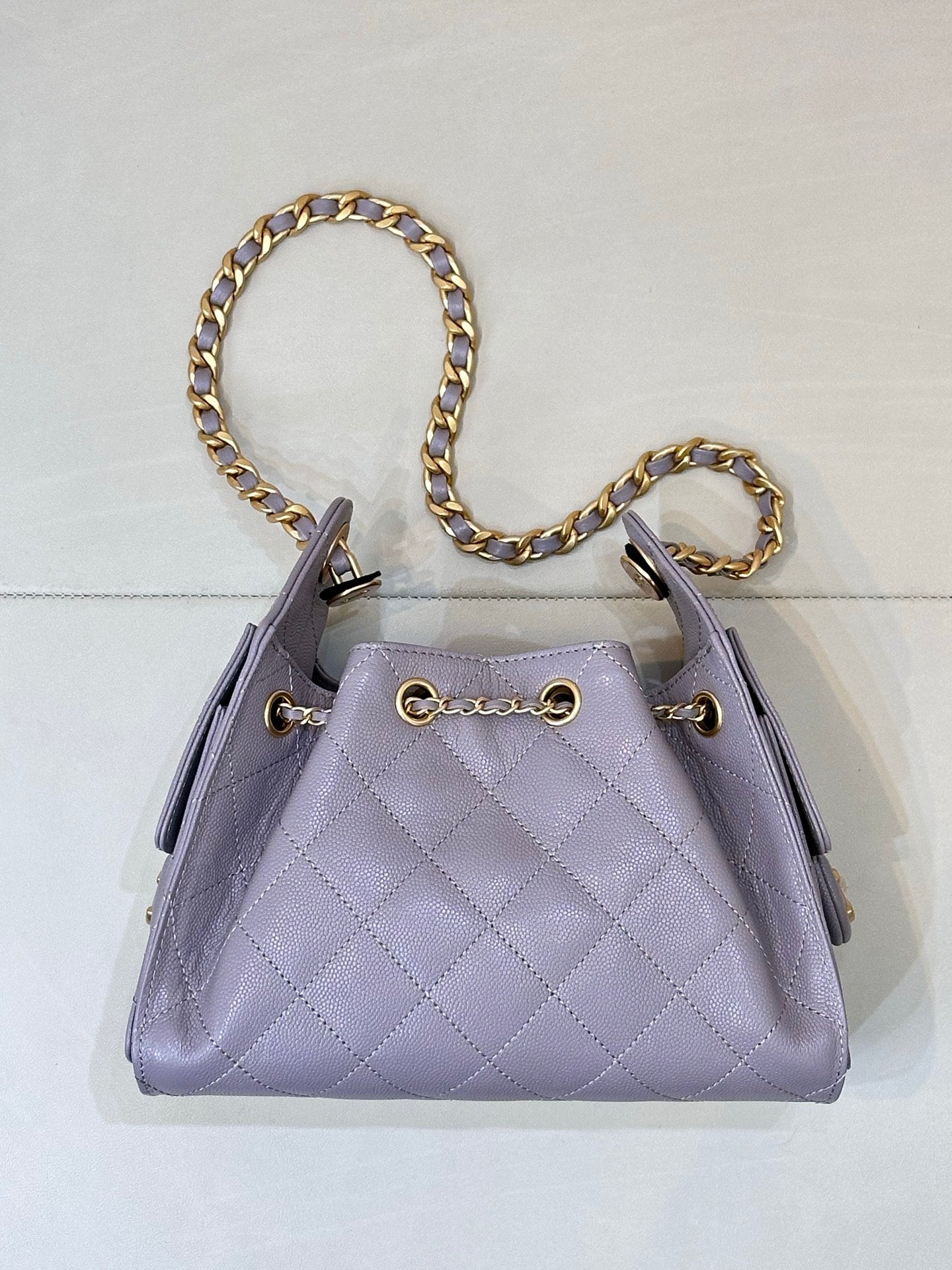 Lavender quilted top-handle bag with gold chain strap and front CC charm