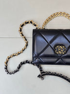 Chanel quilted mini shoulder bag with dark blue flap, gold CC emblem, and chain strap