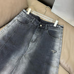 Dark blue denim pants with straight legs, button fly, and triangular Prada logo patch